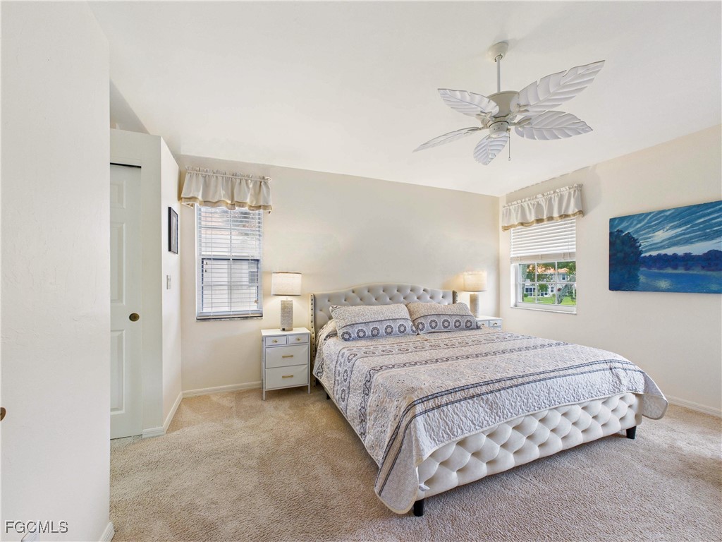 7435 Plumbago Bridge Road, Unit K201 Naples, FL 34109 - Photo 18 of 35 a bedroom with a bed and a chandelier