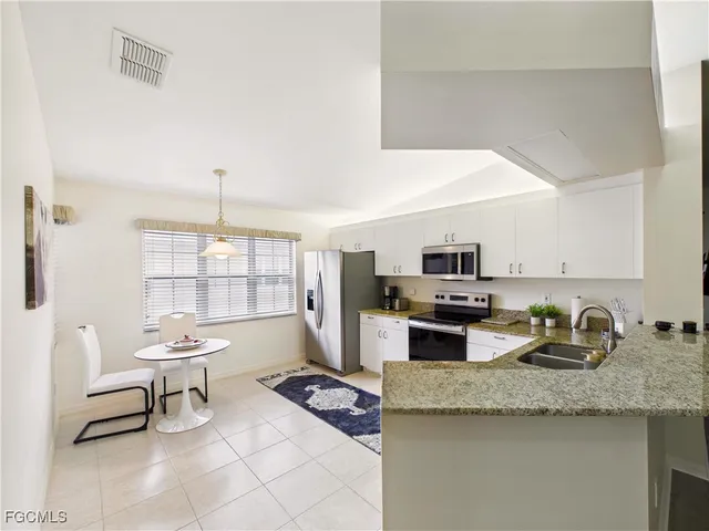 a kitchen with a sink a stove and chairs