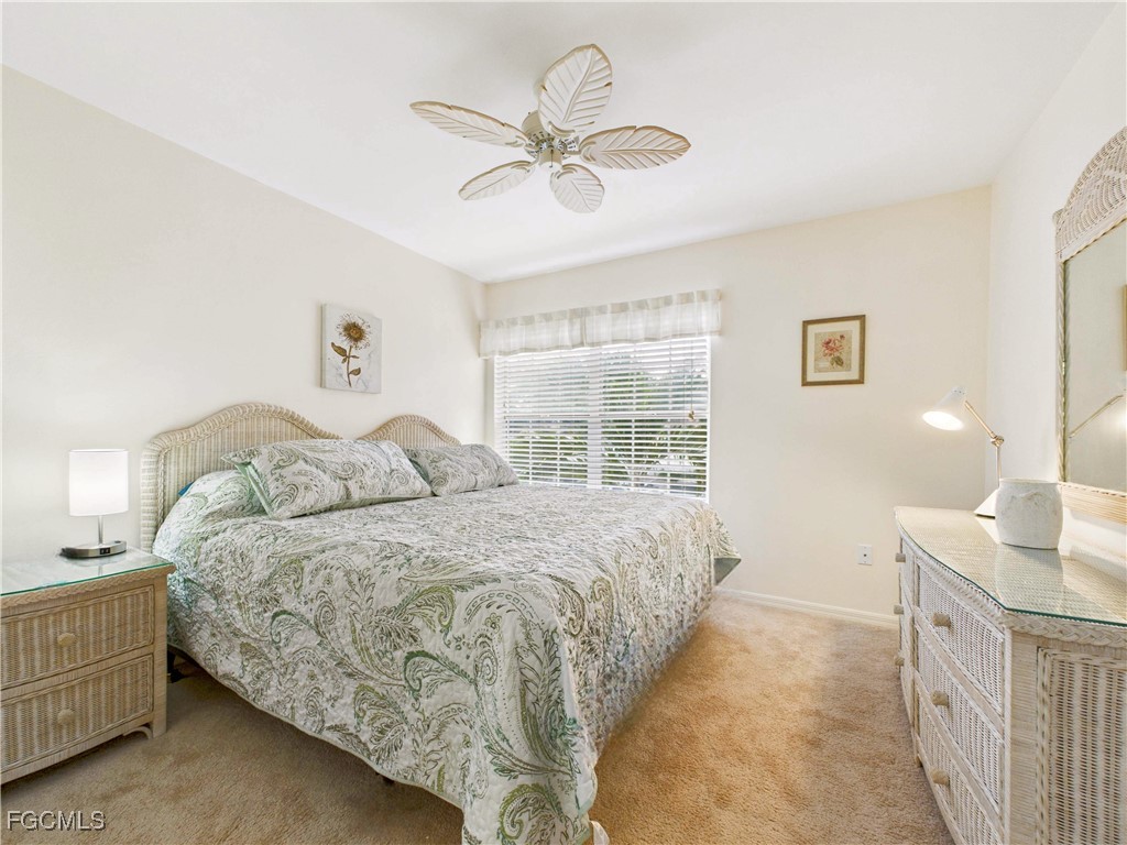 7435 Plumbago Bridge Road, Unit K201 Naples, FL 34109 - Photo 31 of 35 a spacious bedroom with a large bed and a chandelier