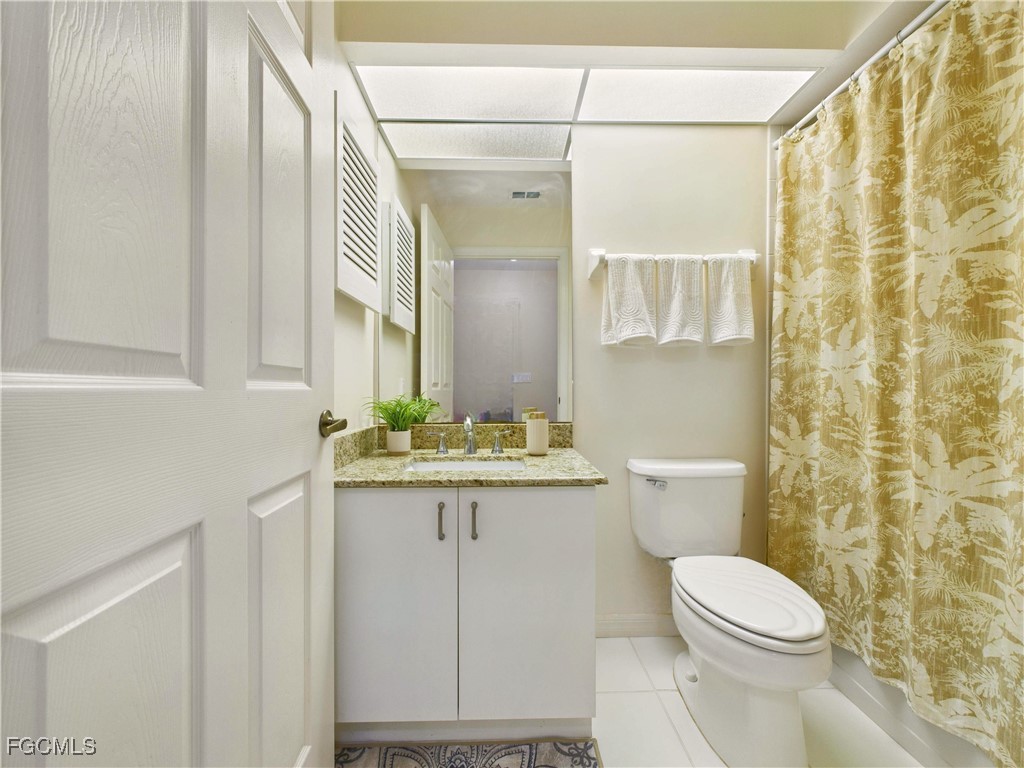7435 Plumbago Bridge Road, Unit K201 Naples, FL 34109 - Photo 33 of 35 a bathroom with a granite countertop sink a toilet and a mirror