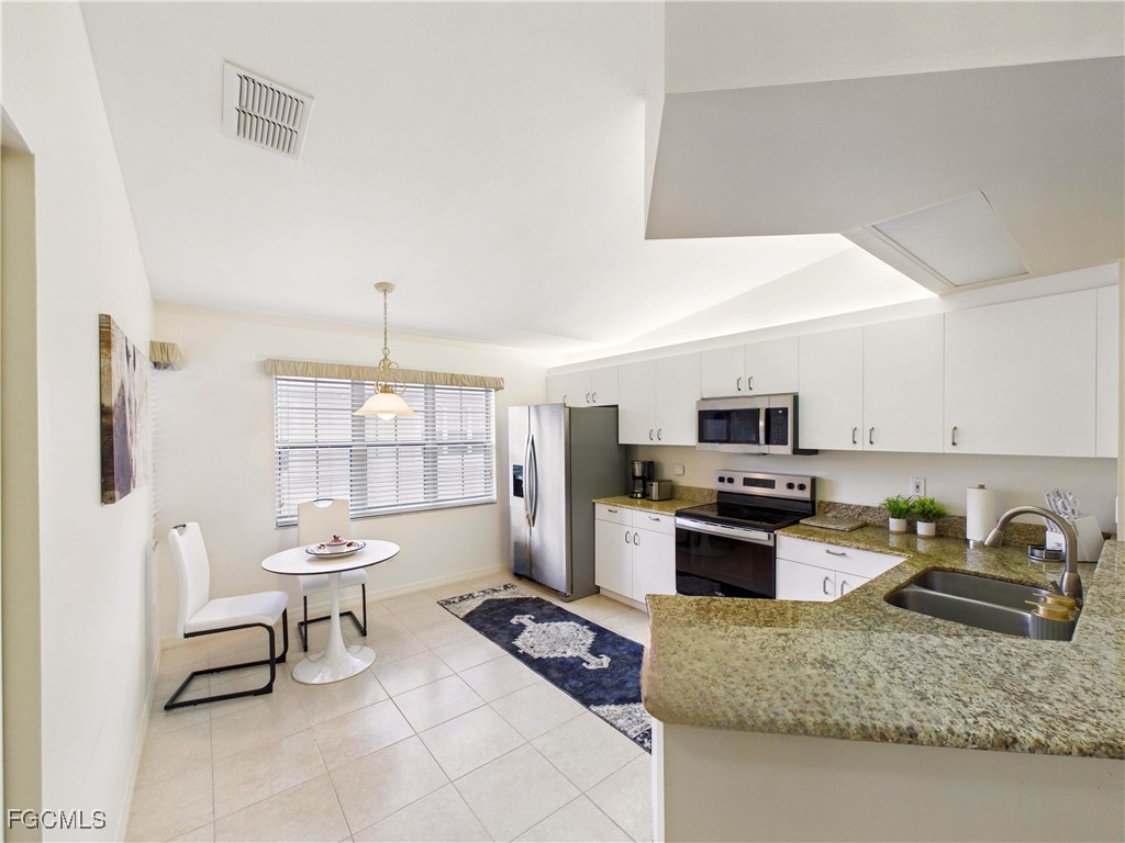 7435 Plumbago Bridge Road, Unit K201 Naples, FL 34109 - Photo 4 of 35 a kitchen with a stove a sink and a refrigerator