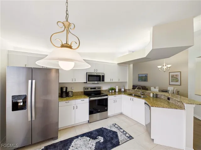 a kitchen with a refrigerator a stove a sink and cabinets