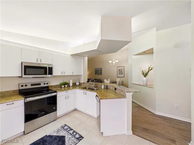a kitchen with a sink a stove top oven and cabinetry