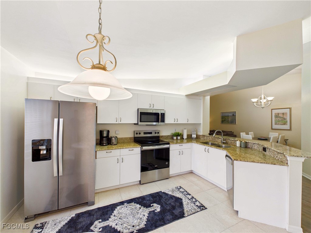 7435 Plumbago Bridge Road, Unit K201 Naples, FL 34109 - Photo 7 of 35 a kitchen with a refrigerator a stove a sink and dishwasher a oven with wooden floor