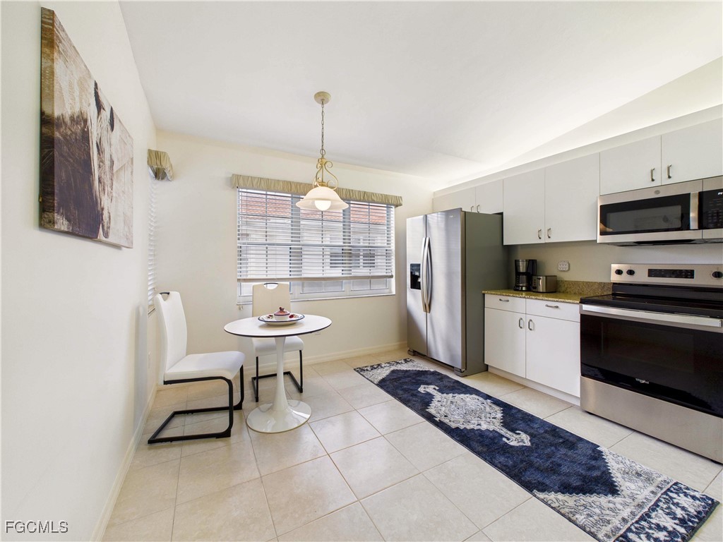 7435 Plumbago Bridge Road, Unit K201 Naples, FL 34109 - Photo 9 of 35 a kitchen with a sink a stove a microwave and cabinets