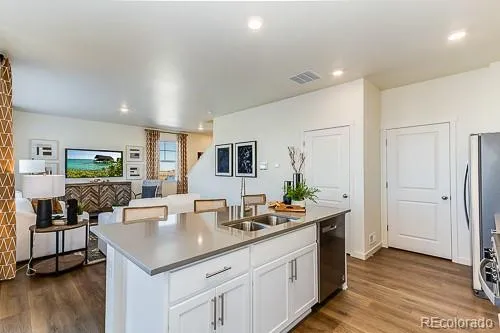 a room with stainless steel appliances kitchen island granite countertop a sink and cabinets
