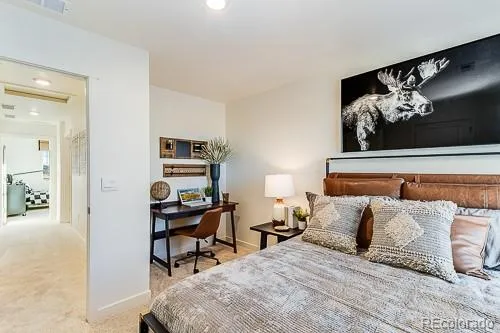 a bedroom with a bed and painting on the wall