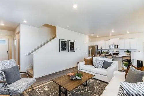 a living room with furniture and view of kitchen