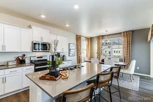 a kitchen with stainless steel appliances granite countertop a sink a stove and a refrigerator