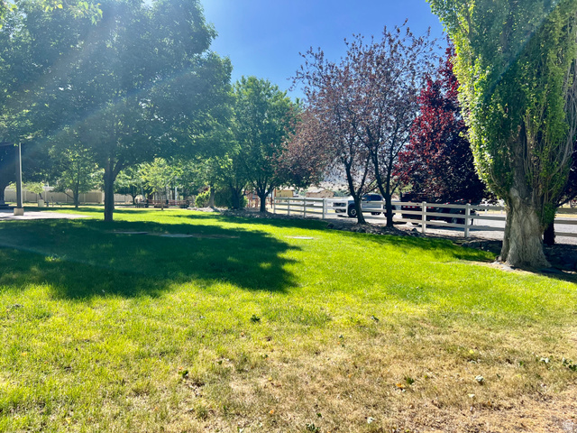 812 East Bates Cyn Road Tooele, UT 84074 - Photo 108 of 144 Expansive outdoor green space featuring mature trees and a white split-rail fence bordering the property