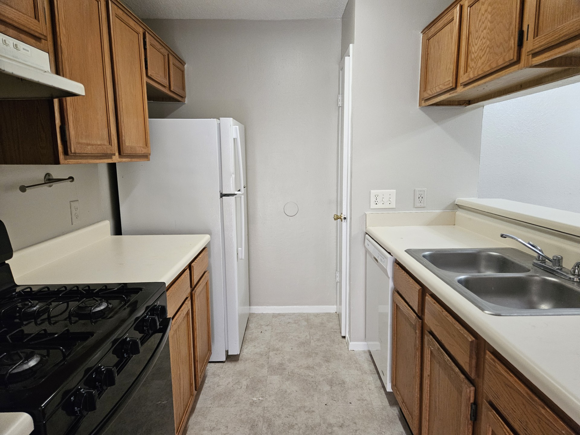 805 Lexington Road, Unit B Elgin, TX 78621 - Photo 3 of 11 A compact kitchen with functional wood cabinetry and essential appliances.