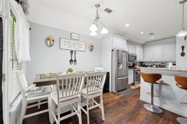 a view of a dining room with furniture a chandelier and wooden floor