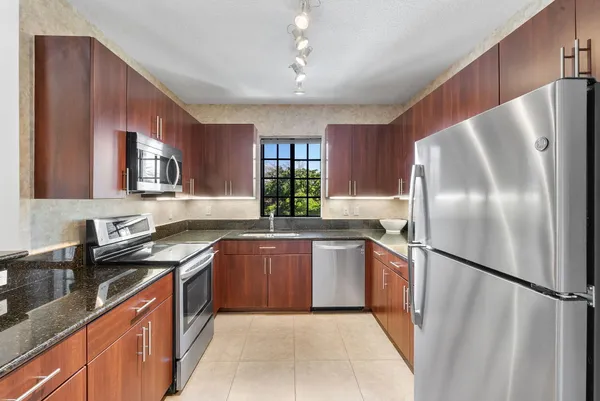 a kitchen with stainless steel appliances a refrigerator and a wooden floor