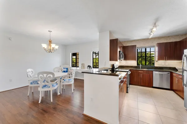 a kitchen with stainless steel appliances granite countertop a refrigerator a sink a stove a washer dryer and a refrigerator