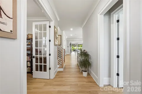 a view of a hallway with wooden floor and a living room