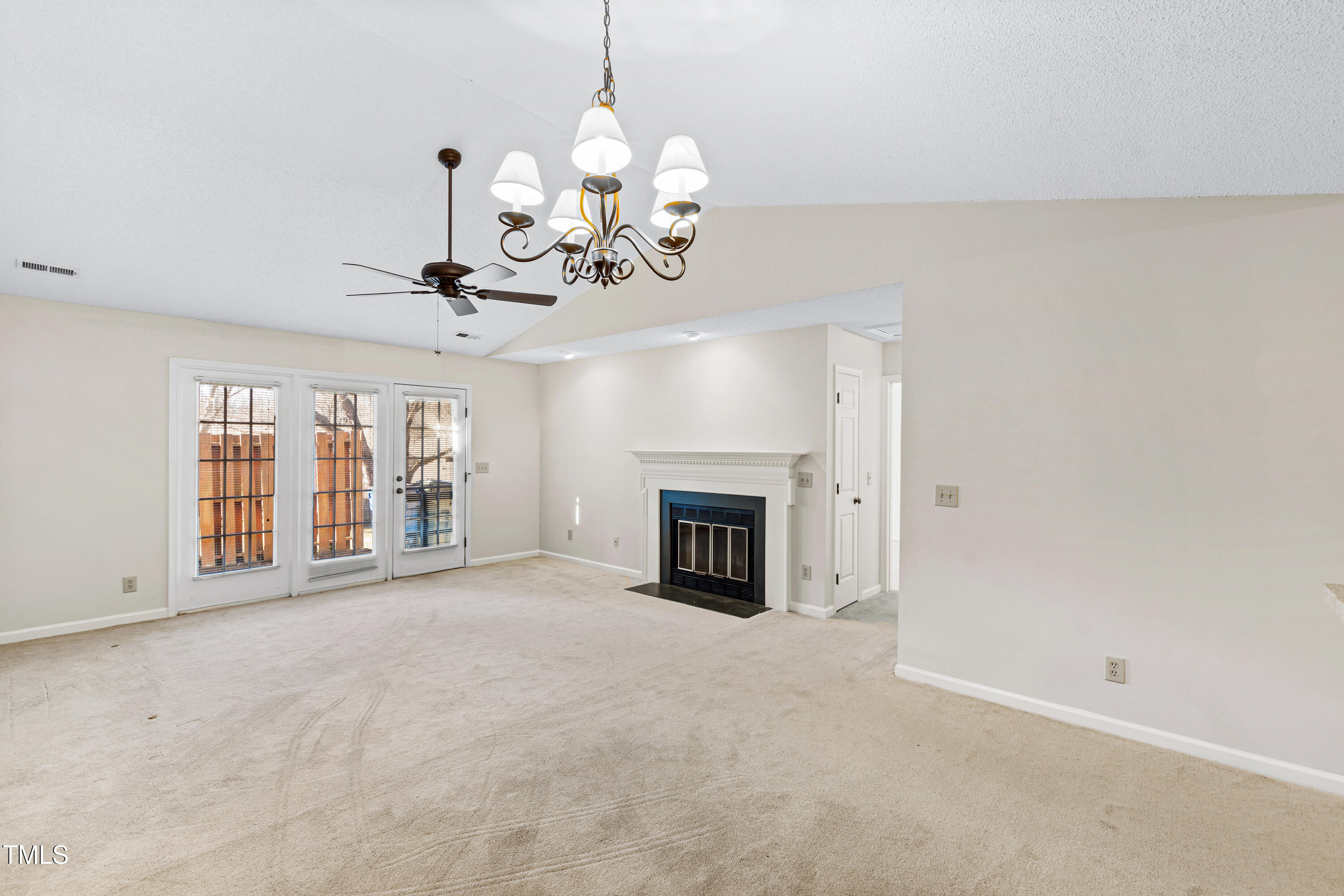2615 Cottage Circle Raleigh, NC 27613 - Photo 12 of 27 a view of a livingroom with a fireplace a chandelier and windows