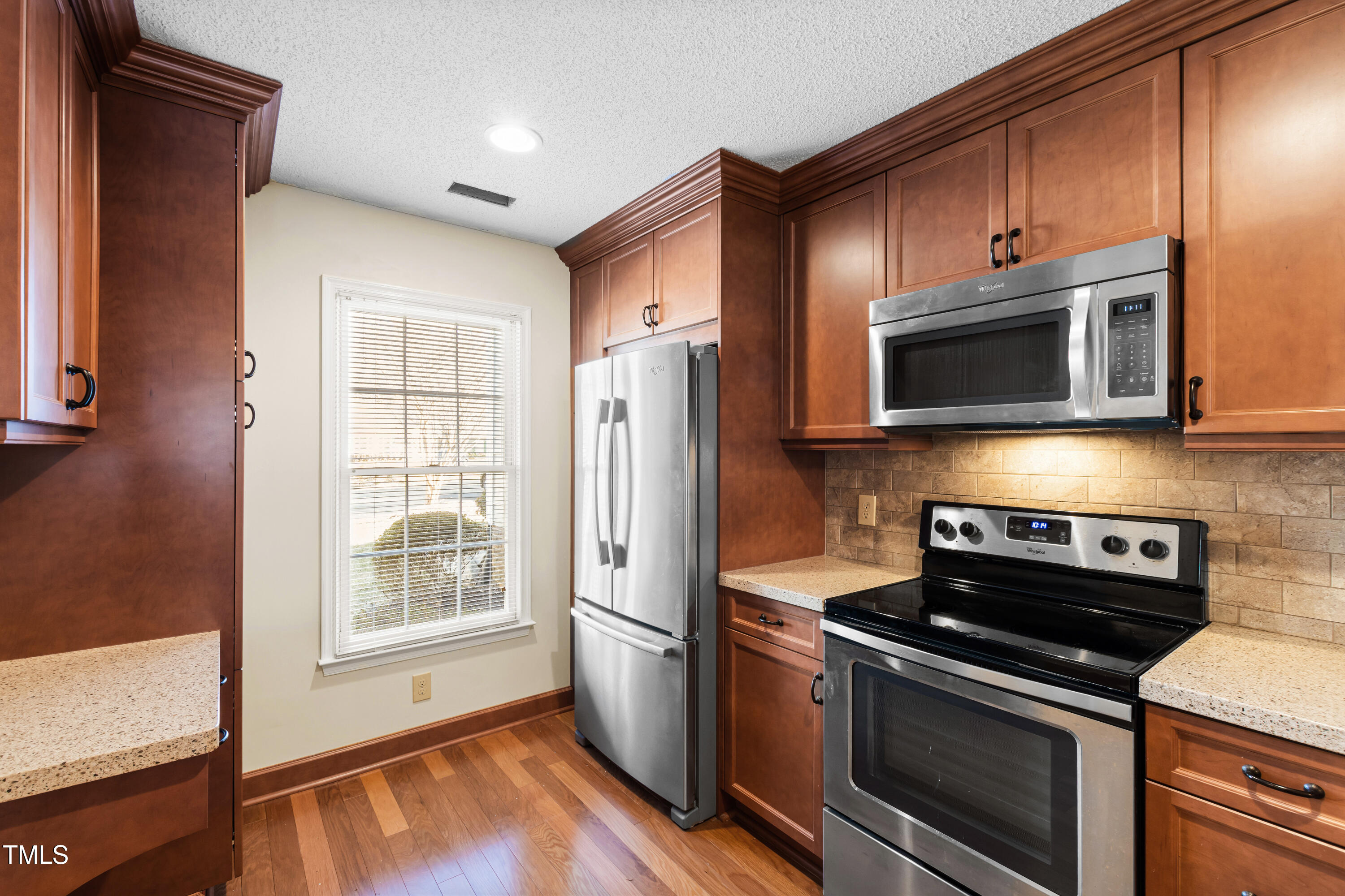 2615 Cottage Circle Raleigh, NC 27613 - Photo 8 of 27 a kitchen with stainless steel appliances granite countertop a stove microwave and refrigerator