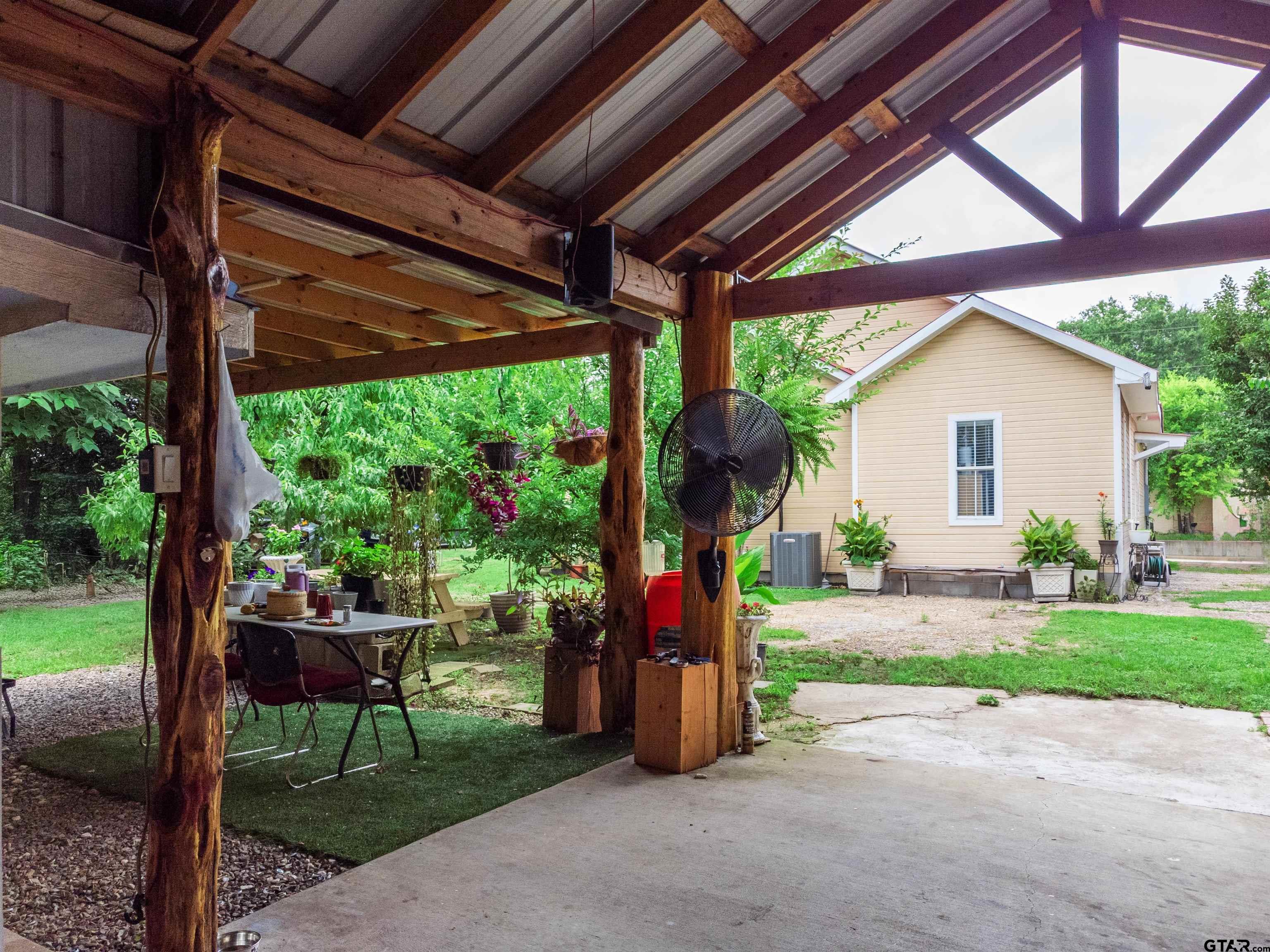 427 East Locust Street Tyler, TX 75702 - Photo 32 of 42 a view of a backyard with table and chairs under an umbrella with a small yard