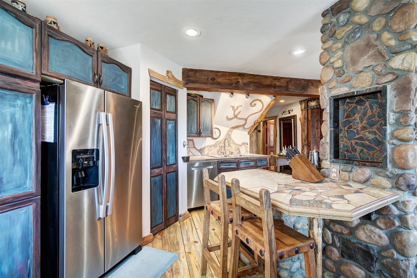 9460 Ryan Gulch Road, Unit 9460 Silverthorne, CO 80498 - Photo 5 of 39 a kitchen with stainless steel appliances granite countertop a refrigerator a oven a sink and a dining table