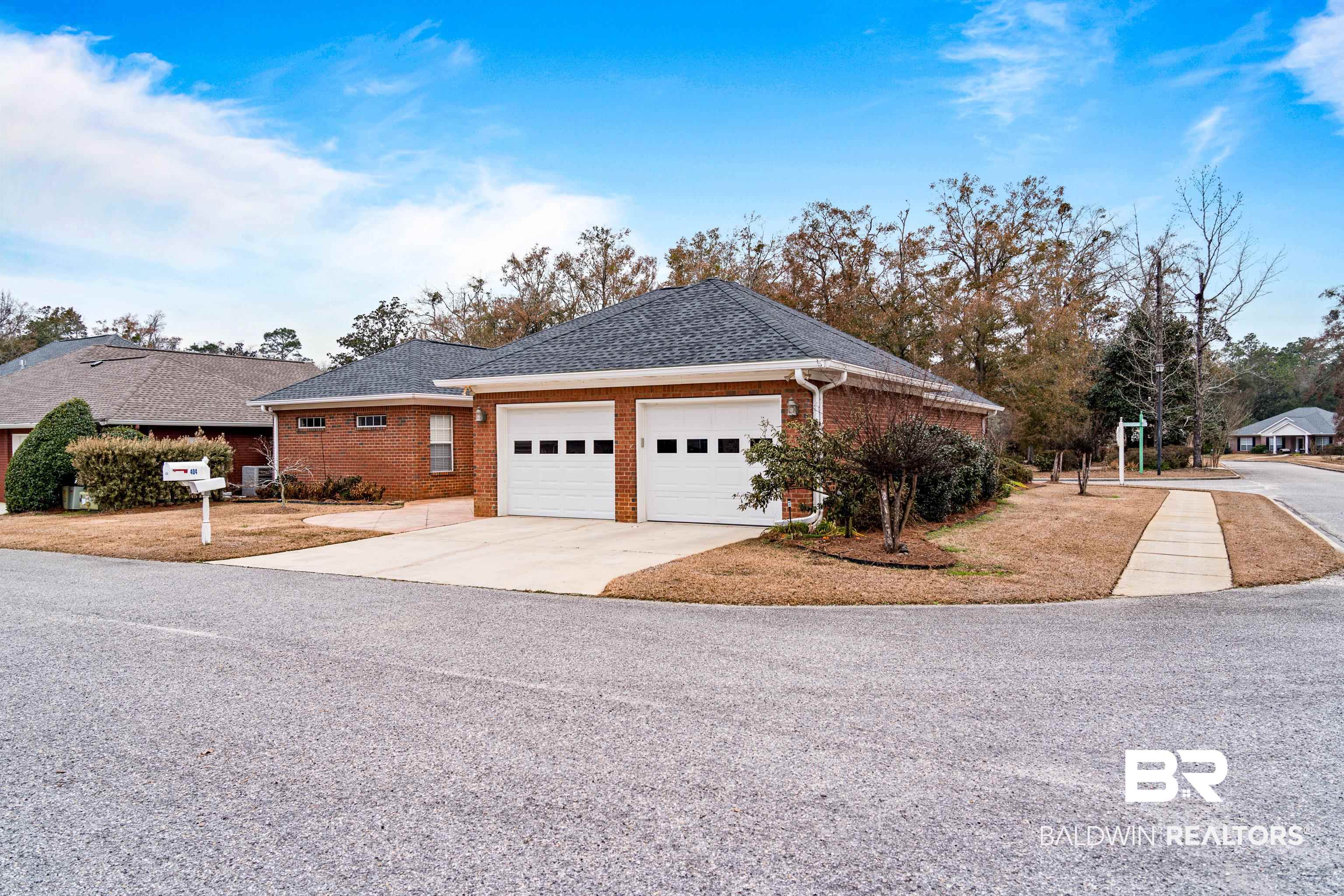 404 Savannah Lane Foley, AL 36535 - Photo 29 of 29 View of front facade with a garage, concrete driveway, brick siding, and roof with shingles