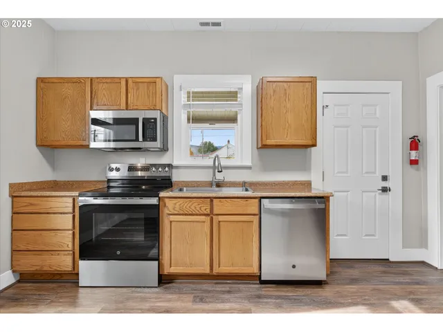a kitchen with stainless steel appliances a stove microwave and sink