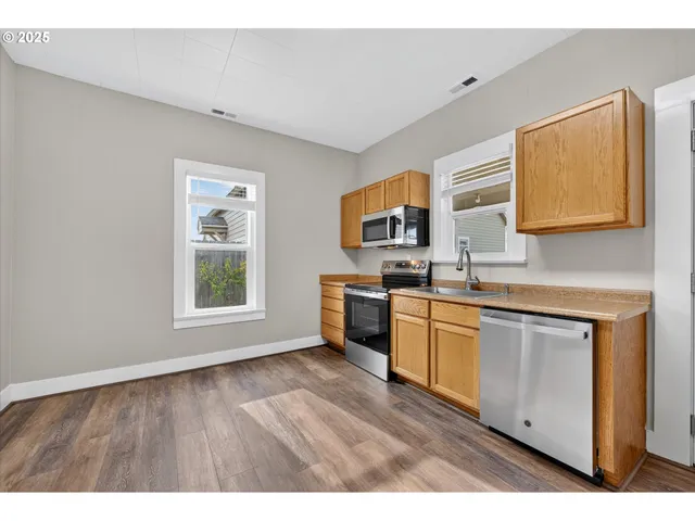 a kitchen with stainless steel appliances a stove top oven a sink dishwasher and a microwave