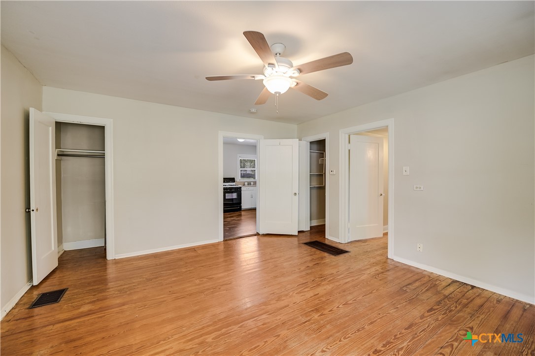 600 County Road 152 Georgetown, TX 78626 - Photo 13 of 24 a view of an empty room with wooden floor and a ceiling fan