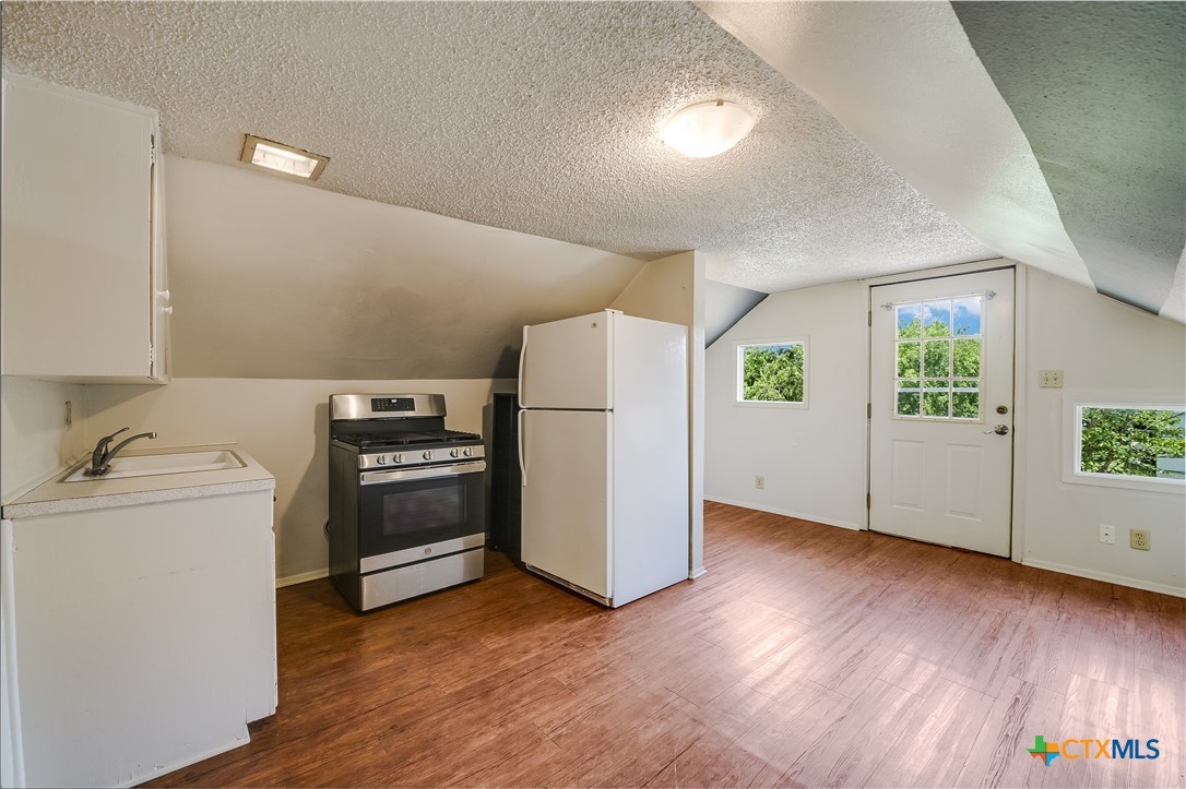 600 County Road 152 Georgetown, TX 78626 - Photo 17 of 24 a view of a kitchen with a stove top oven a refrigerator and a microwave
