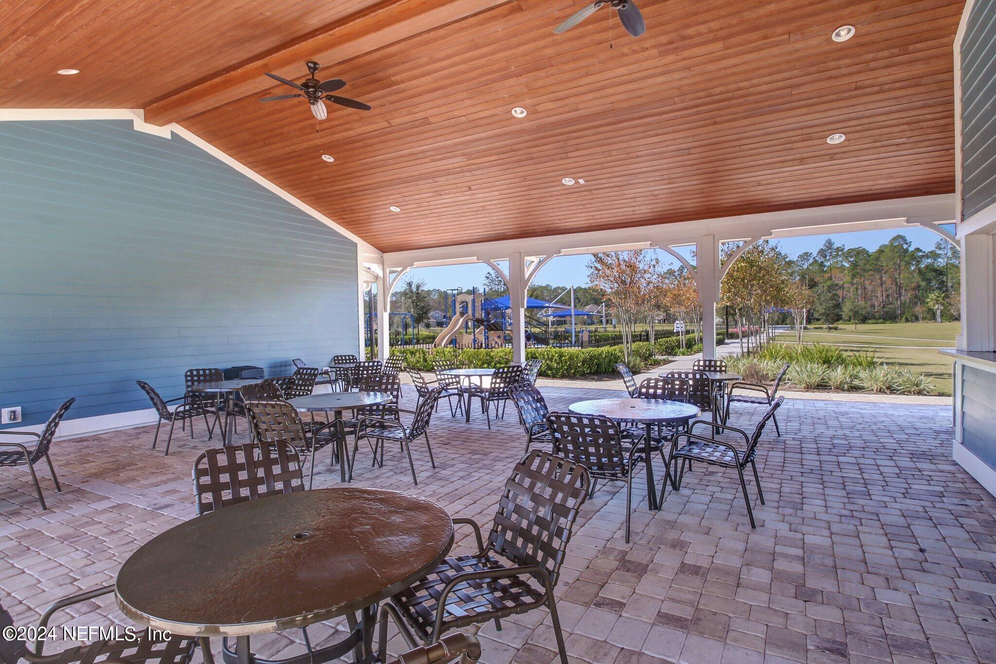 577 Aspen Leaf Drive Jacksonville, FL 32081 - Photo 53 of 106 a outdoor space with lots of tables a garden and chairs