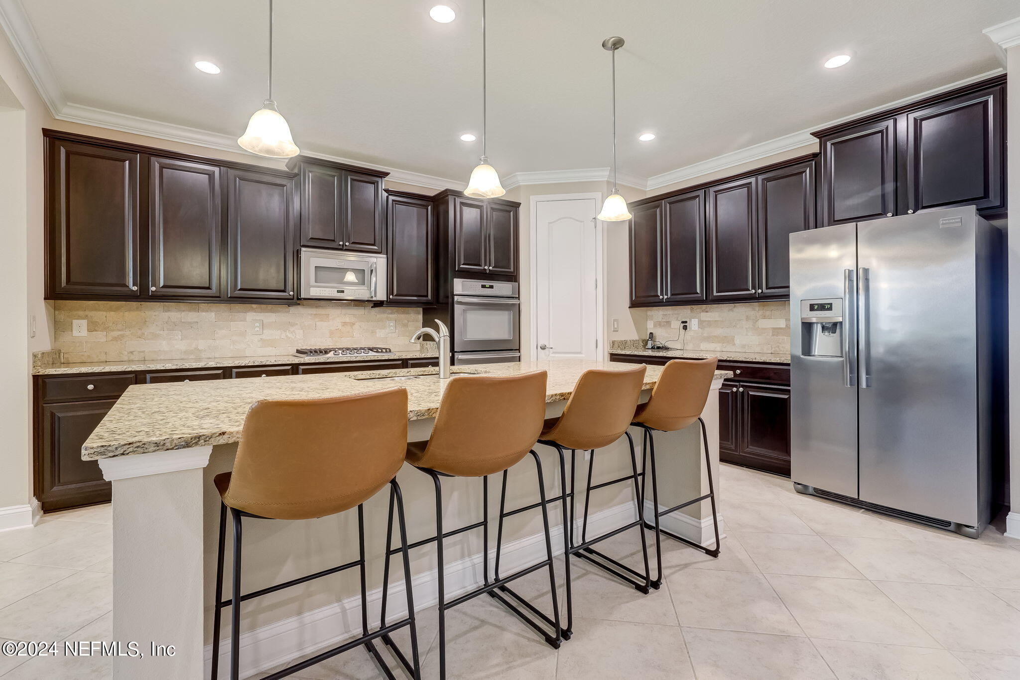 577 Aspen Leaf Drive Jacksonville, FL 32081 - Photo 8 of 106 a kitchen with stainless steel appliances granite countertop a refrigerator a stove a sink a dining table and chairs