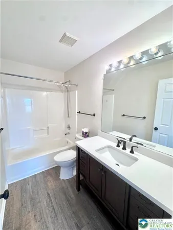 a bathroom with a double vanity sink toilet mirror and bathtub