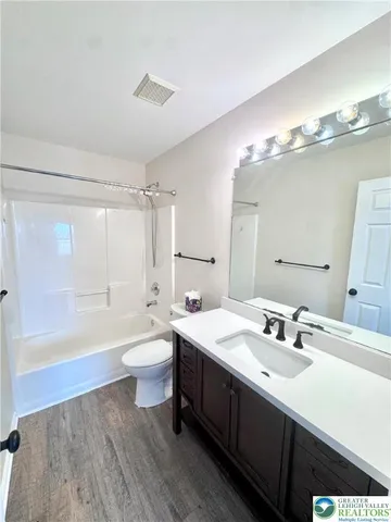 a bathroom with a double vanity sink toilet mirror and bathtub