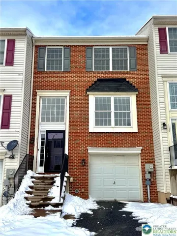 a front view of a house with a parking space