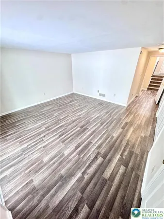 a view of a room with wooden floor
