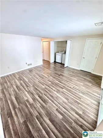 a view of empty room with wooden floor