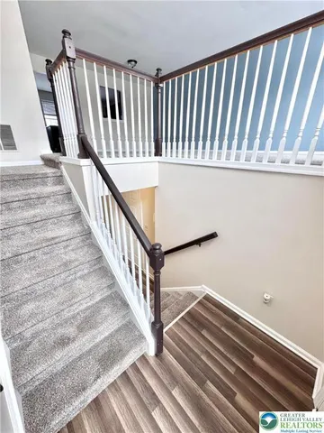 a view of staircase with white walls and railing