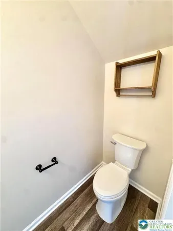 a white toilet sitting next to a white wall