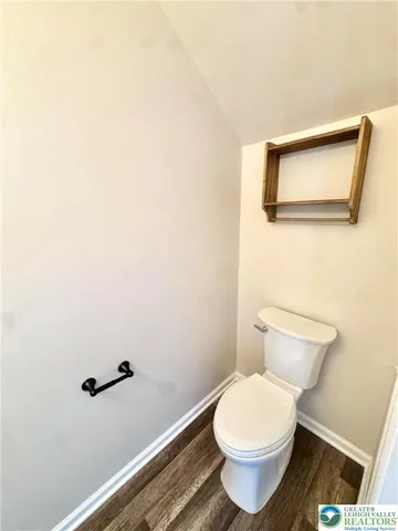 a white toilet sitting next to a white wall