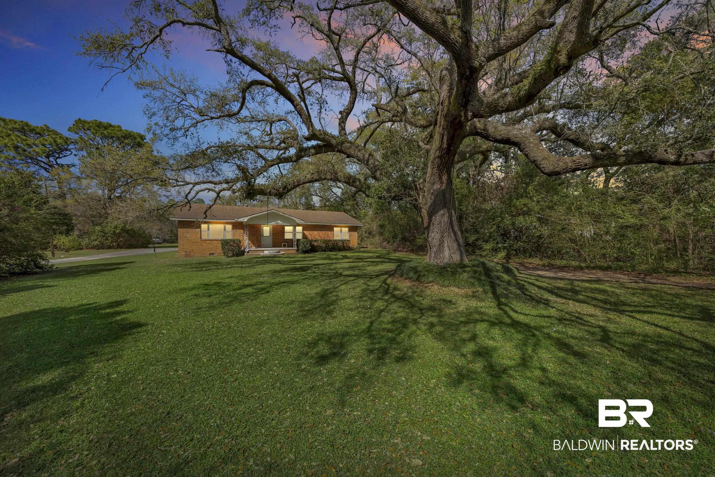 17463 Highway 98 Foley, AL 36535 - Photo 30 of 57 View of front of property featuring a front lawn, brick siding, and view of scattered trees