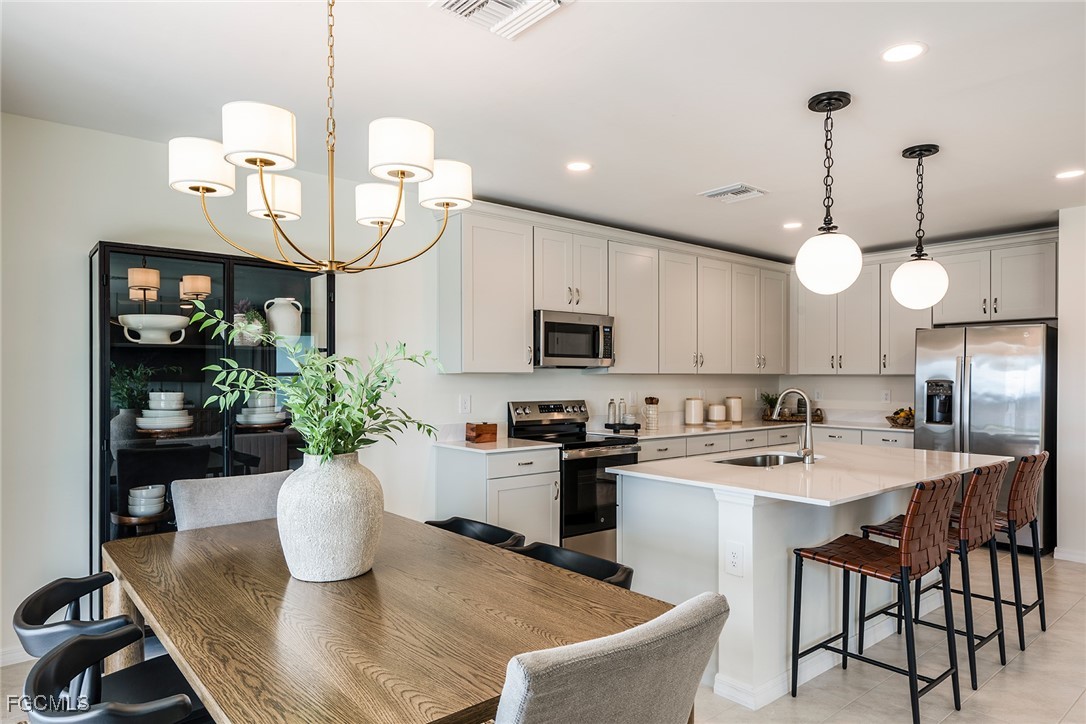237 Moonlit Lk Trail Lehigh Acres, FL 33974 - Photo 6 of 18 a kitchen with wooden floor and stainless steel appliances