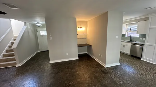 an empty room with wooden floor and electronic appliances