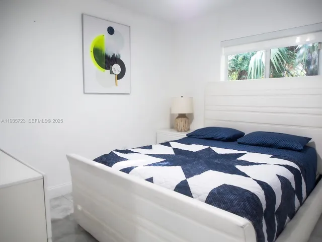 a bedroom with a bed and painting on the wall