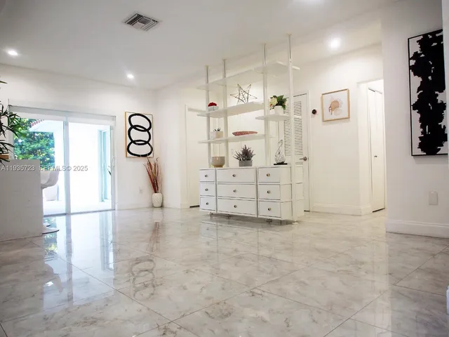 a kitchen with stainless steel appliances granite countertop a refrigerator a stove top oven a sink dishwasher and couches with wooden floor