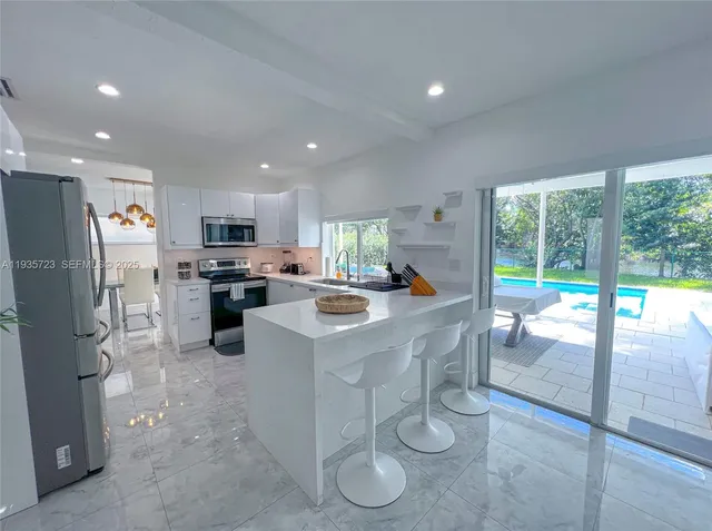 a kitchen with stainless steel appliances a refrigerator a stove a microwave and cabinets