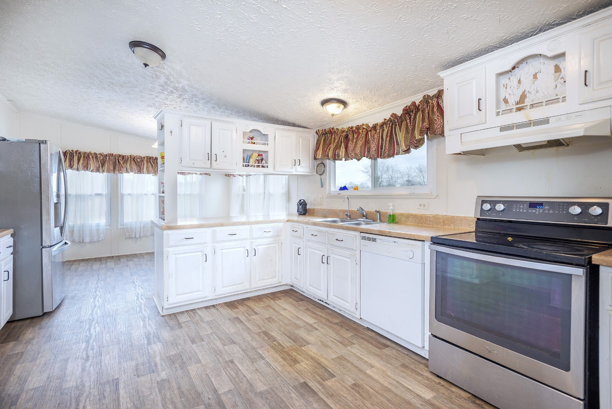 4936 Youngville Road Springfield, TN 37172 - Photo 5 of 20 a kitchen with stainless steel appliances granite countertop a stove and white cabinets with wooden floors