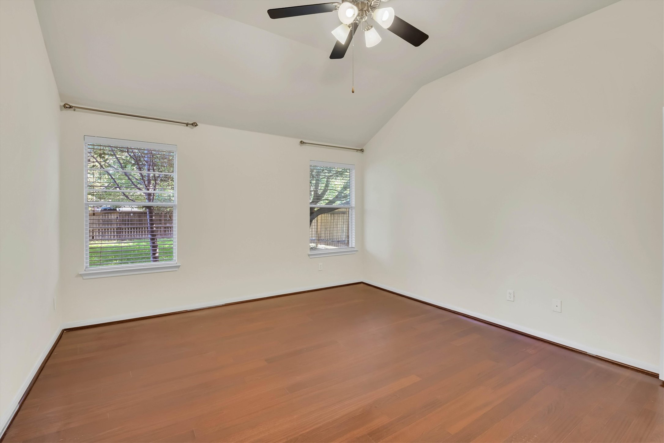 18420 Masi Loop Pflugerville, TX 78660 - Photo 15 of 33 Spacious room featuring vaulted ceilings, wood-finish flooring, and two windows with white blinds