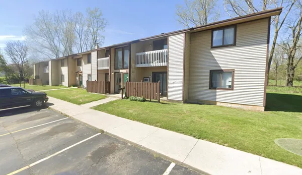 a view of a house with a yard and pathway
