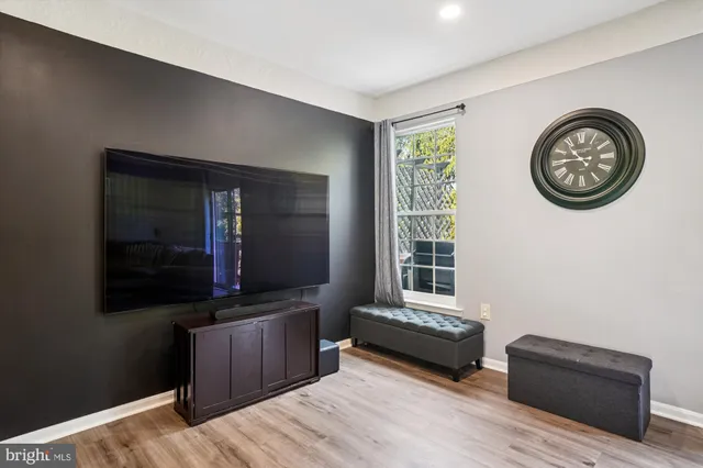 a living room with furniture and a dining table with wooden floor