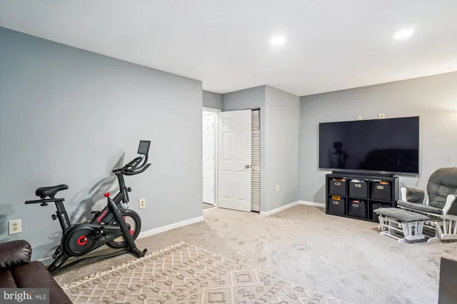 a kitchen with stainless steel appliances a refrigerator a stove top oven a sink dishwasher a dining table and chairs with wooden floor