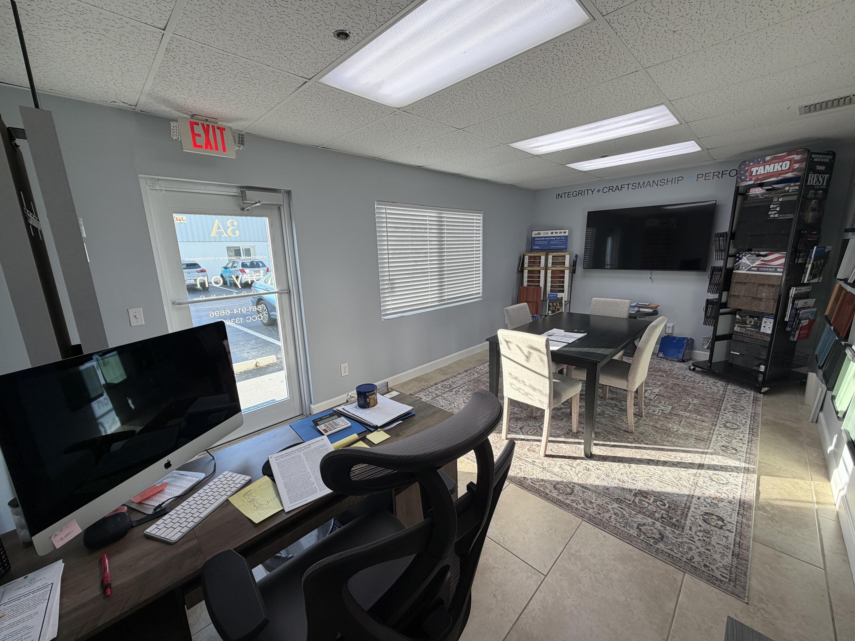1312 Commerce Lane, Unit 3A Jupiter, FL 33458 - Photo 2 of 10 a living room with furniture a flat screen tv and a refrigerator